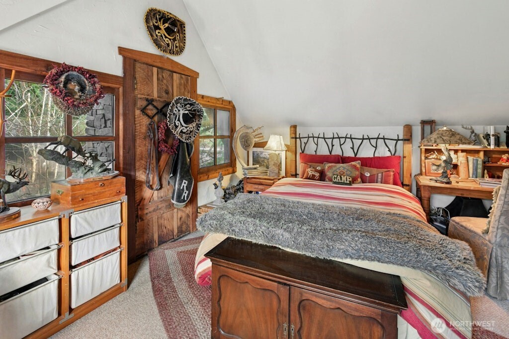 Upstairs bedroom with vaulted ceilings and balcony/deck