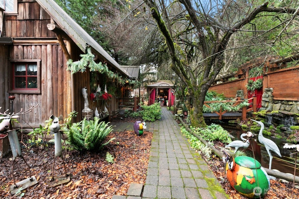 Looking across front of the home at Koi pond/bridge and gated entry to right. Garage is ahead in the distance behind the Gazebo.  All currently being used as part of the Christmas Shop at Timber Creek Active Business (for sale separately)