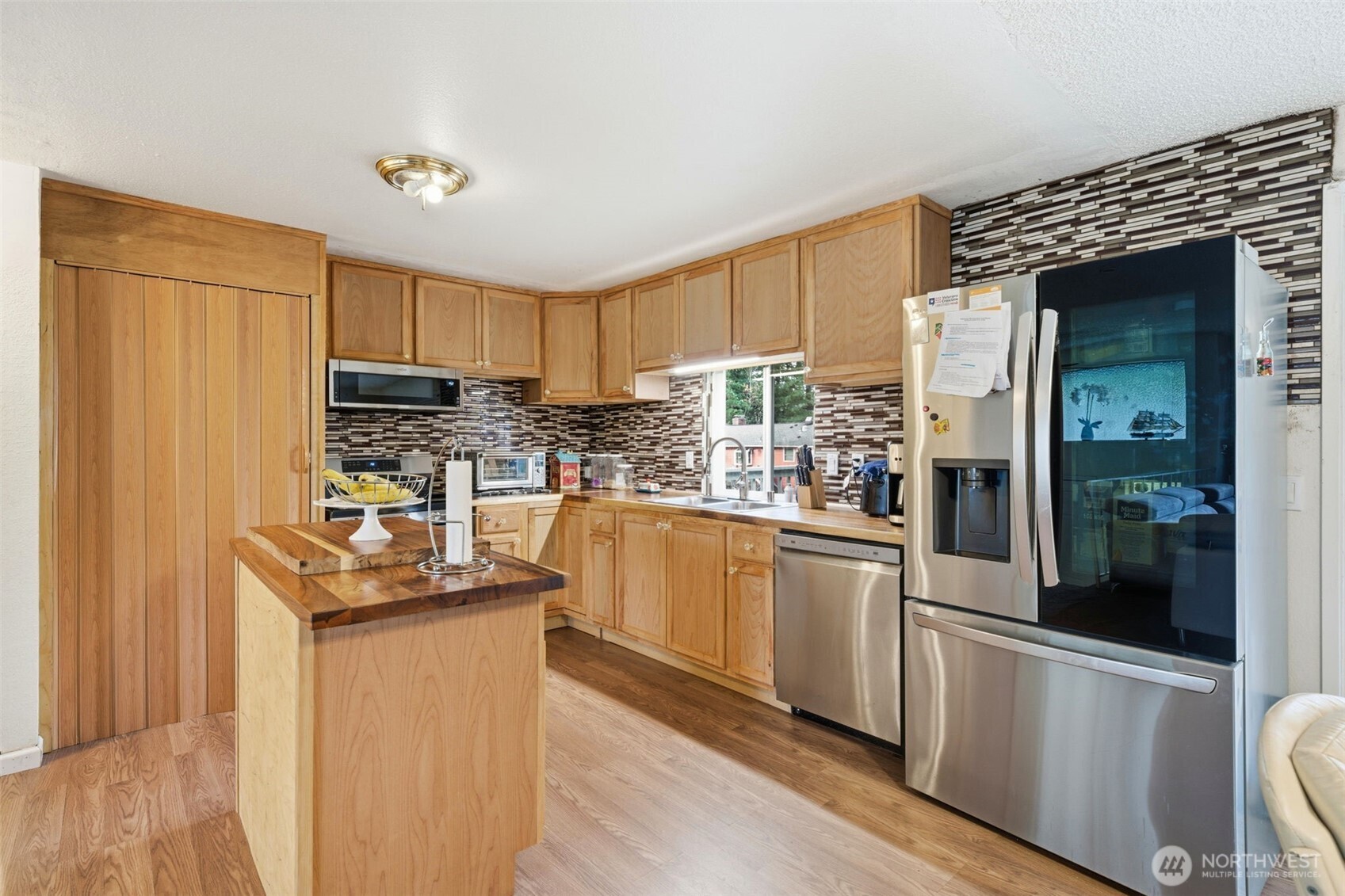 Beautiful remodeled kitchen featuring granite countertops and backsplash, stainless steele appliances, and island!