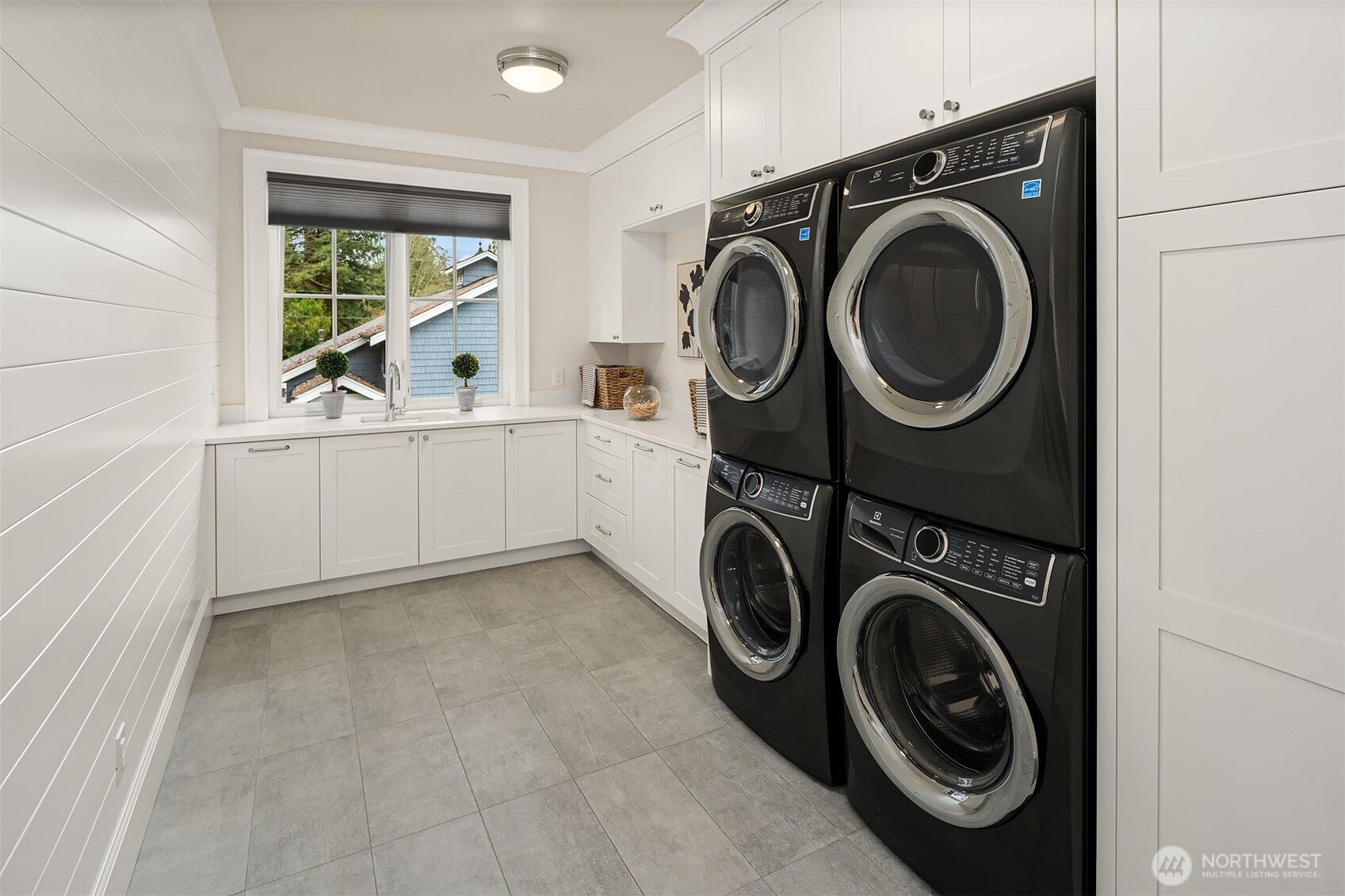 The laundry room is equipped with a double stack washer and dryer, providing efficient use of space and the ability to handle multiple loads simultaneously. Ample counter space is available in the laundry room, making it convenient for folding clothes. Additionally, there are drawers designed for storage.