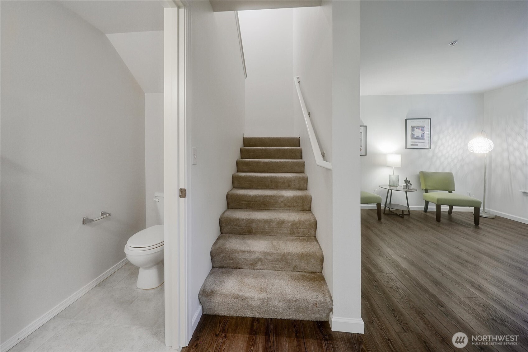 This photo shows the powder room to the left of the stairs & the sitting room to the right. The stairs lead up to the 2nd bedroom & loft area