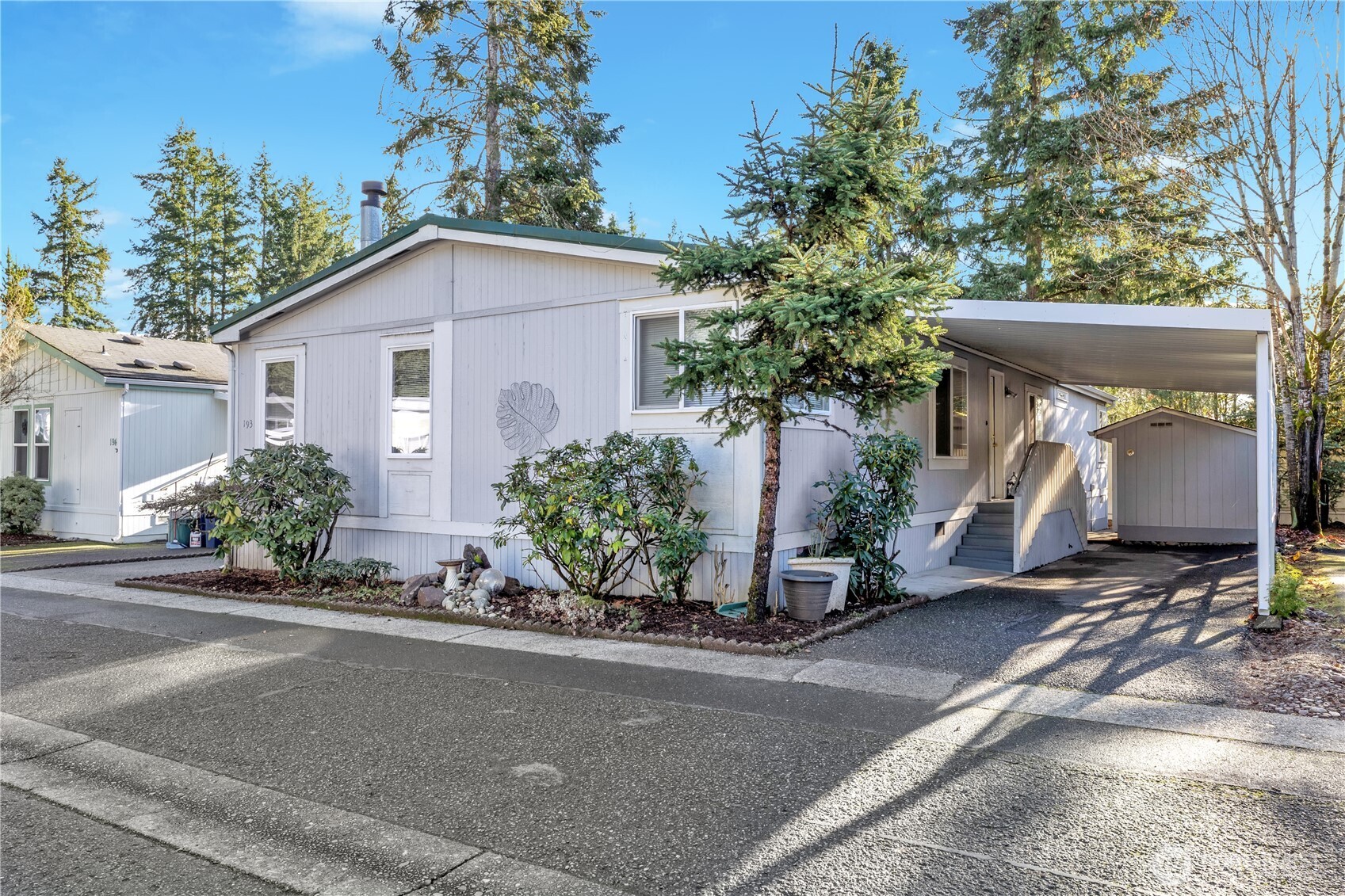 Carport is great for staying dry when bringing groceries in the house. Really nice shed with power & storage shelves. Rhodies will be be spectacular in a few months.