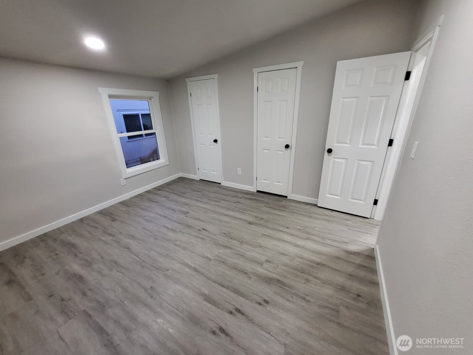 Bedroom #2; We just entered through the doorway on the far right wall. The two closed doors are a linked, ultra spacious closet w/ clothing bar from end to end w/ storage shelf on top (can be walked through!)