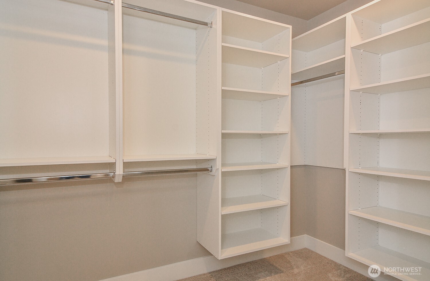 Primary bedrooms's walk-in closet with custom shelving.