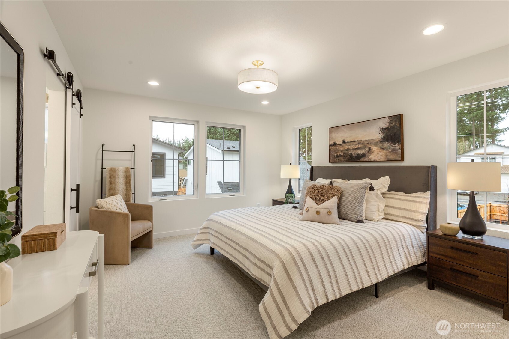 Primary bedroom with four windows, recessed lighting, and a centered ceiling fixture.