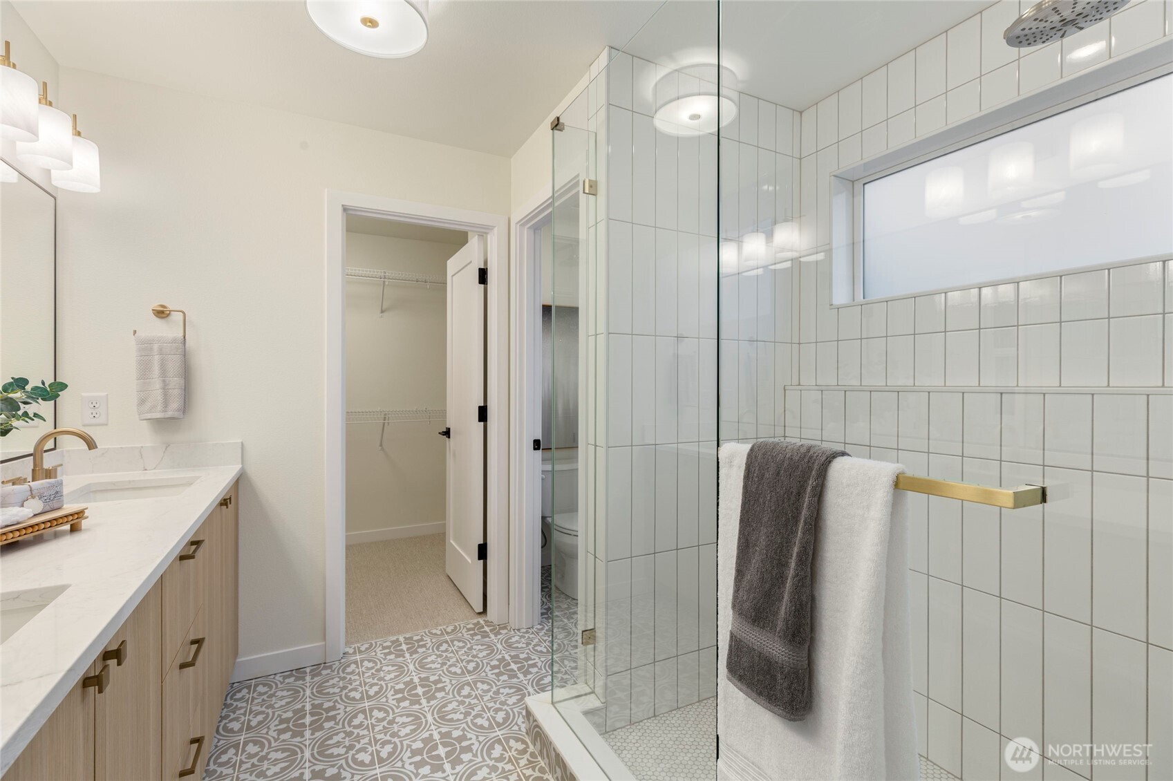 Modern bathroom with double vanity and a glass-enclosed shower.