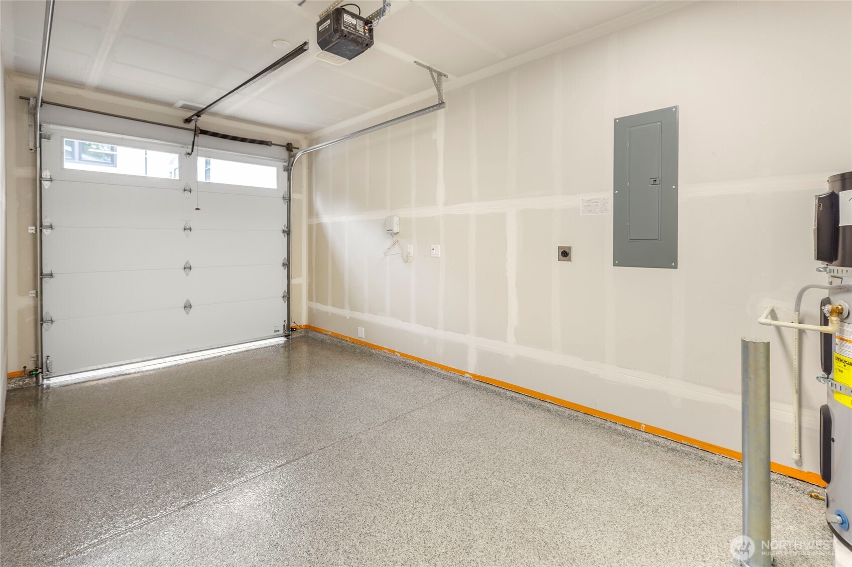 Clean single space garage with speckled epoxy floor and modern fixtures.
