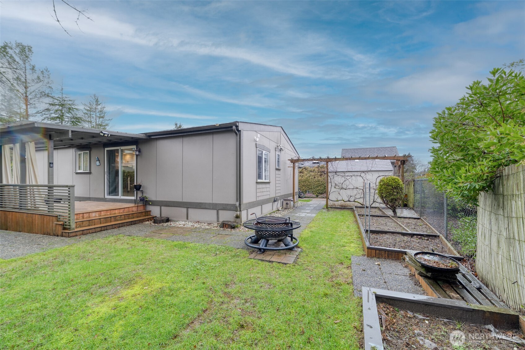 Large side/backyard offering ample space for gardening, a fire pit, and additional outdoor entertaining or storage options