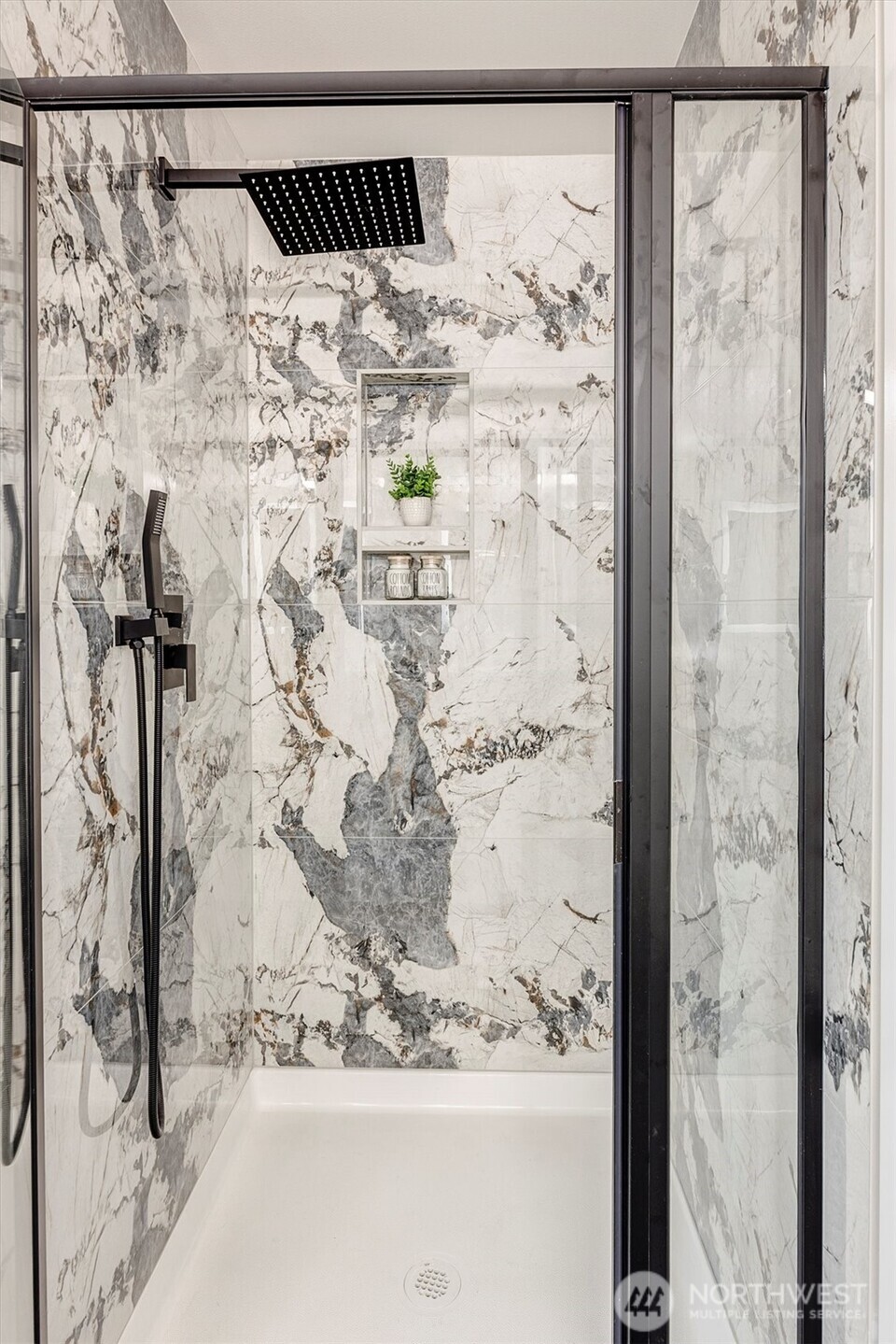 Shower in primary bath has rain head and handheld sprayer.