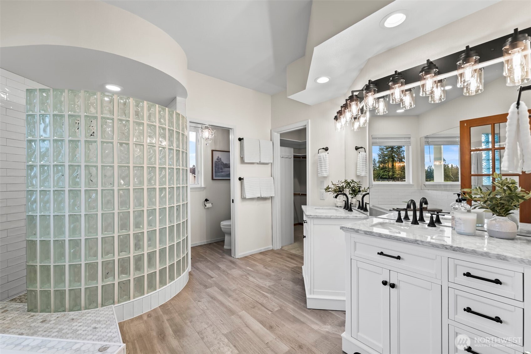With a large walk-in shower, separate vanities, a toilet room...