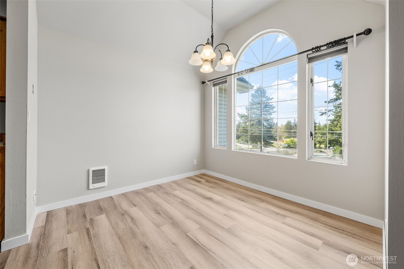 Formal dining room with beautiful arched window making this room light and bright.