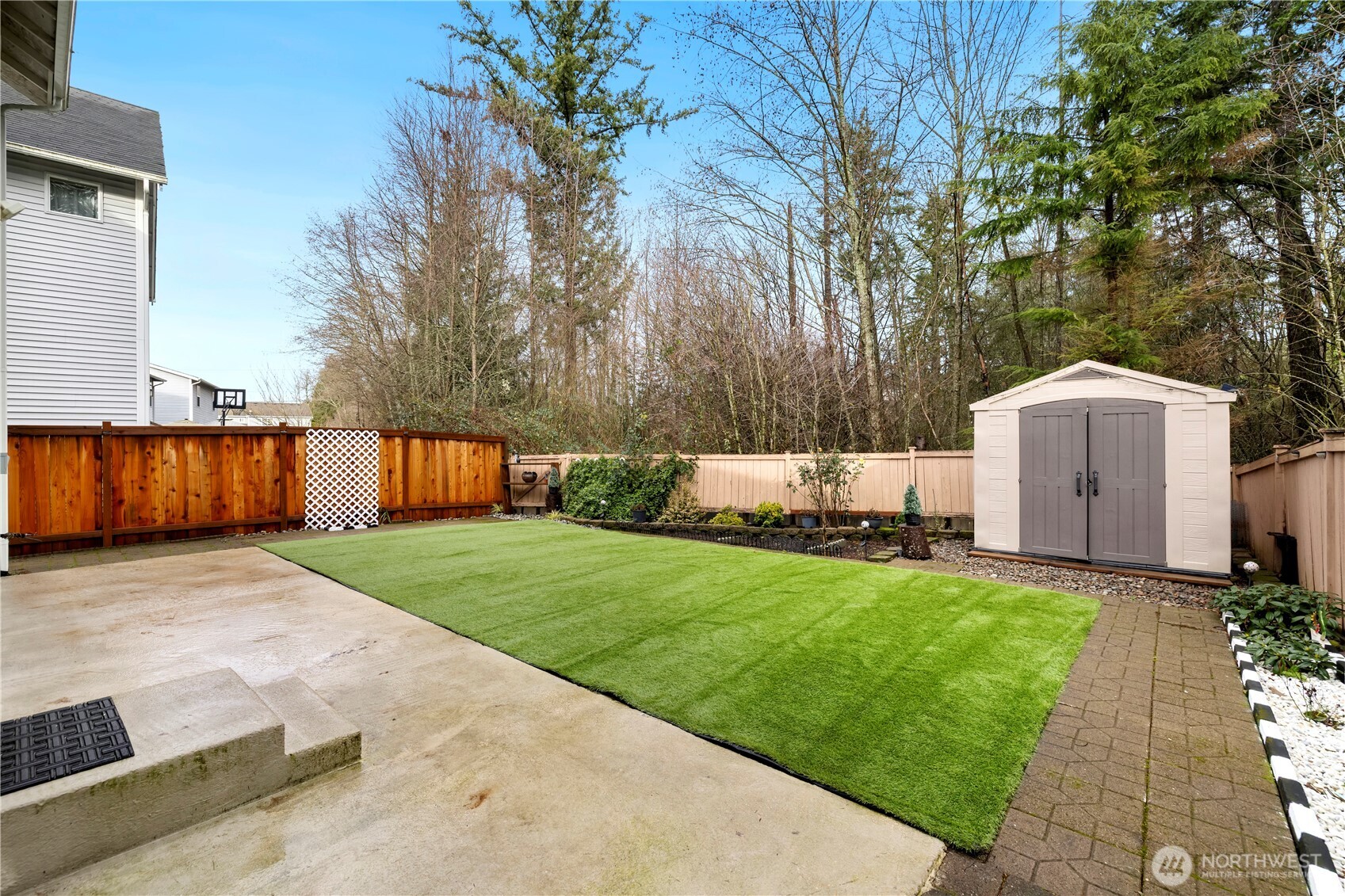 Entertaining sized backyard with long patio for  family gatherings, bricks on surrounding walking path, outdoor shed for storage, designated for gardening.