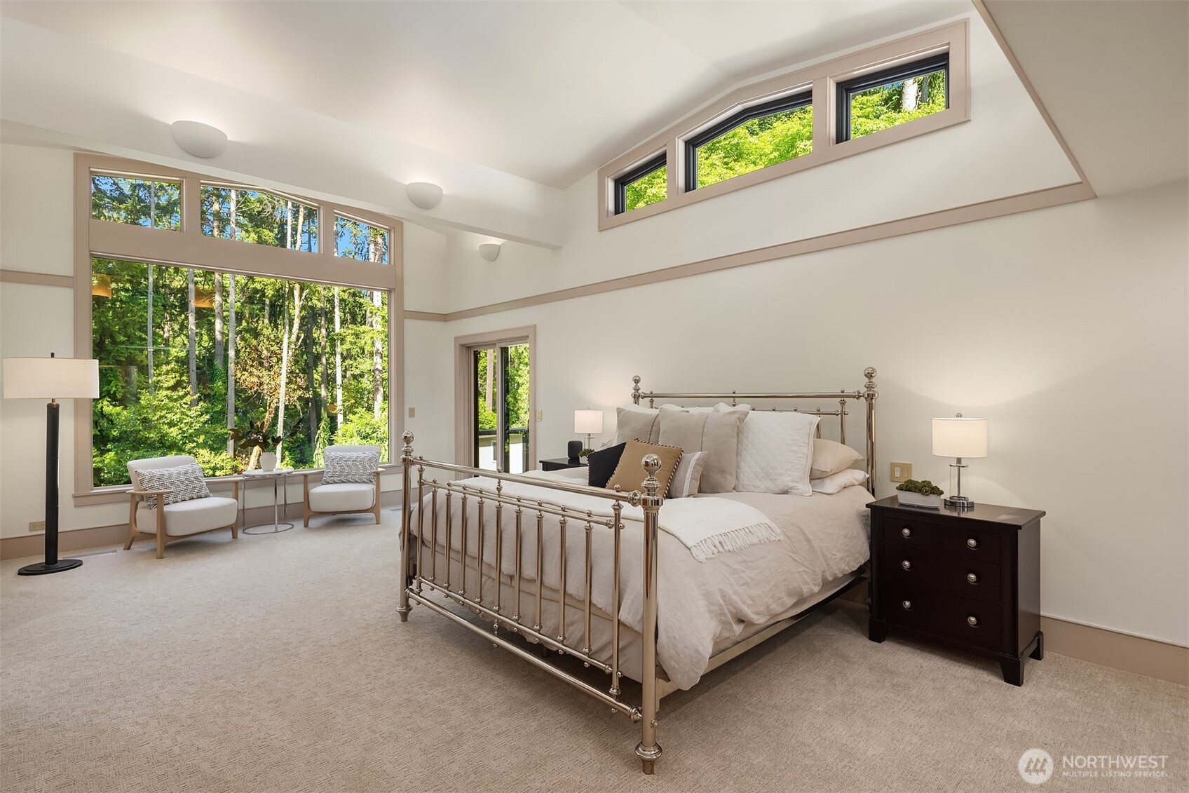 The main-floor primary suite is a true sanctuary, featuring dramatic clerestory windows that frame stunning backyard and park views.