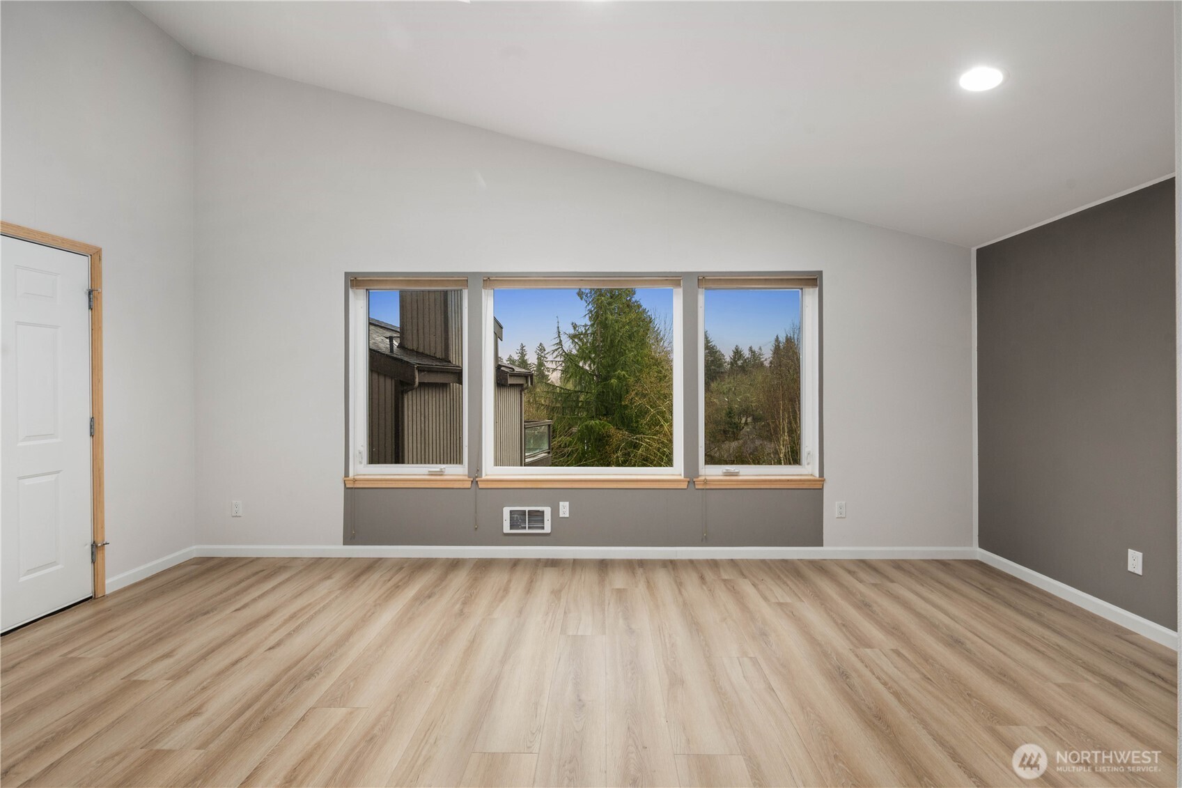 Sleek lower level updated bathroom featuring double vanity, quartz counters, framed mirror, modern lighting, glass shower enclosure, and clean contemporary finishes.