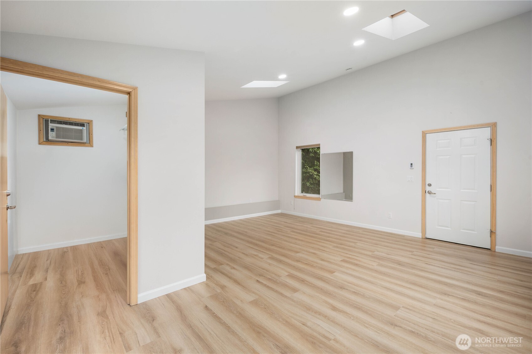 Spacious flex space above two car garage with wide plank floors, large windows, recessed lighting, and flexible layout offering comfort, privacy, and serene natural views.