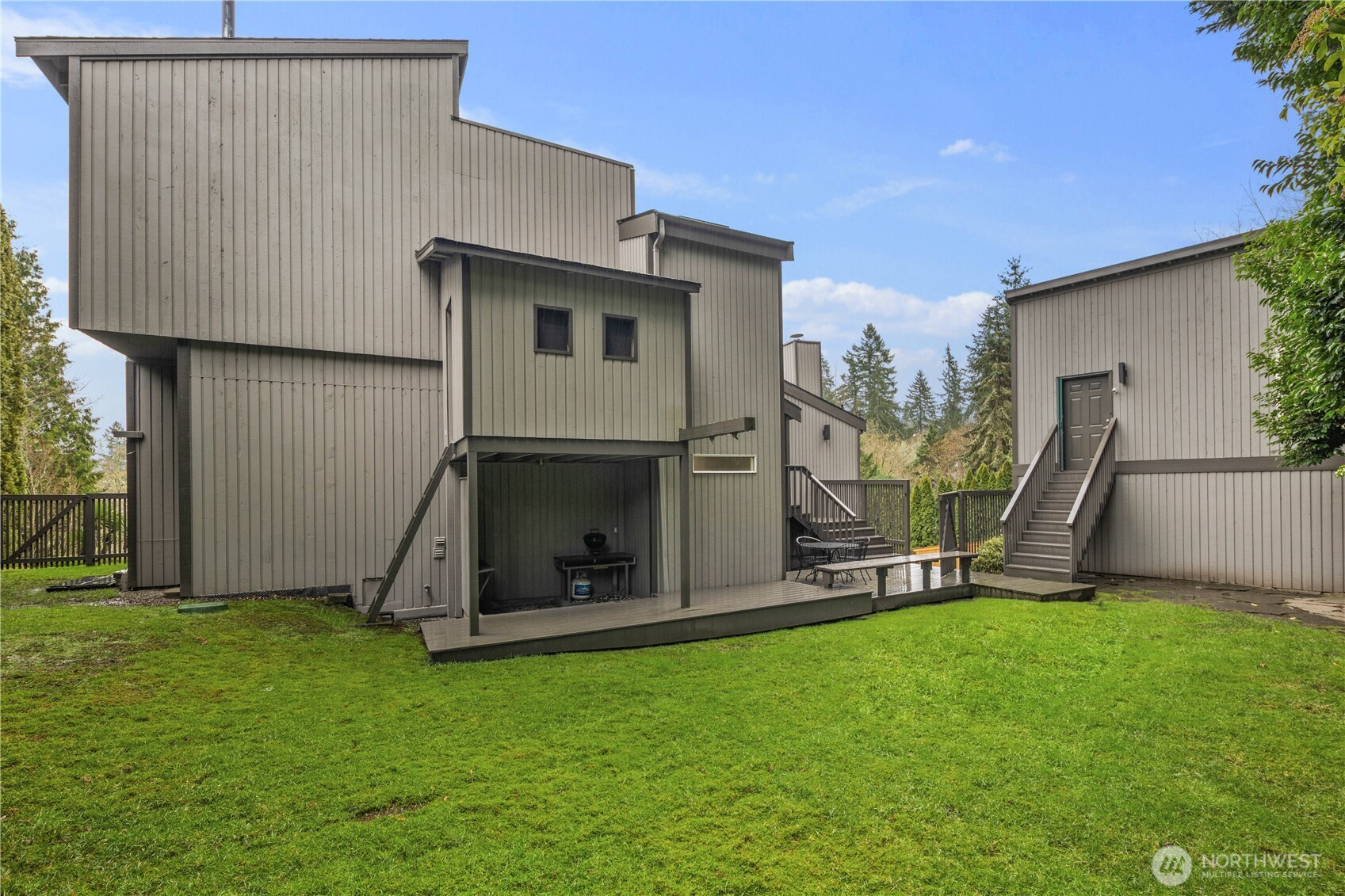 Modern multi-level home with expansive lawns, private decks, and clean architectural lines set amid mature landscaping and open green space.