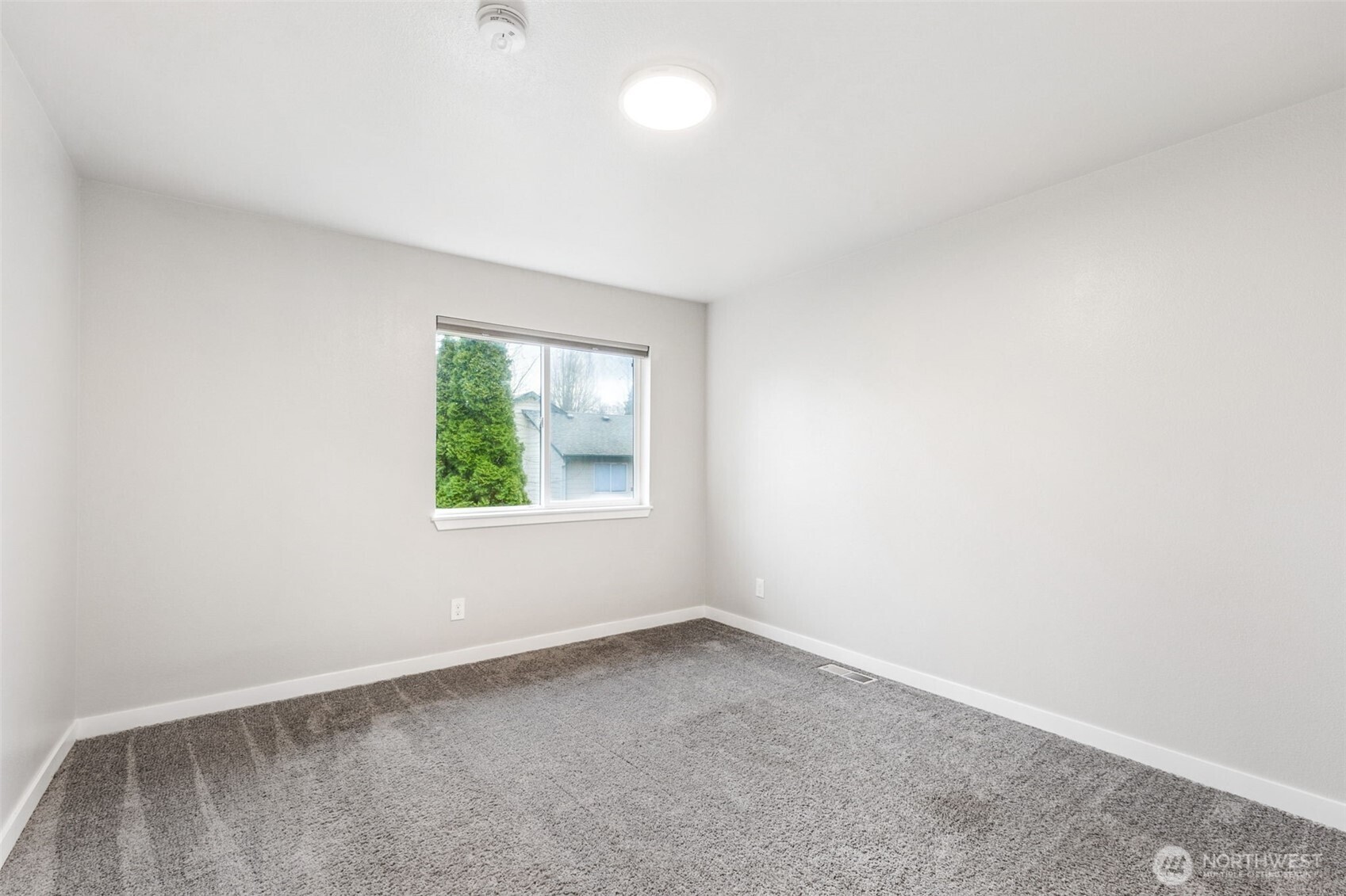 Another view of the primary bedroom with its vaulted ceilings and entry into the private full bathroom.