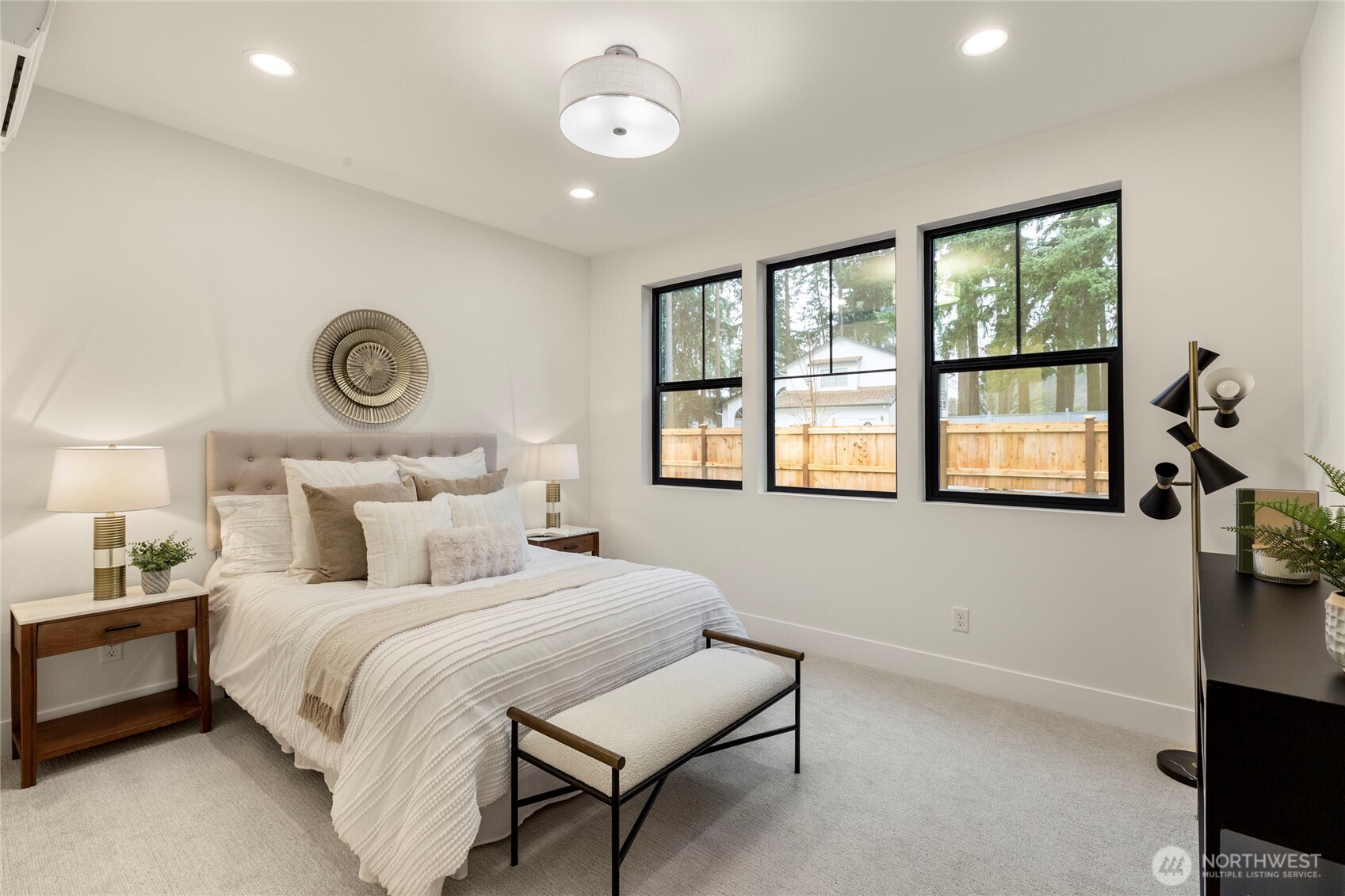 Three large windows offers plenty of natural light in the first floor's primary bedroom.