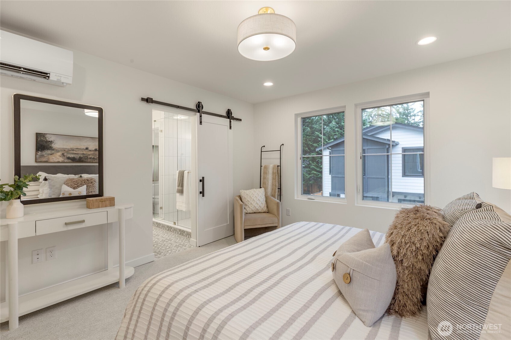 Cozy primary with a barn door leading to the tiled bathroom.