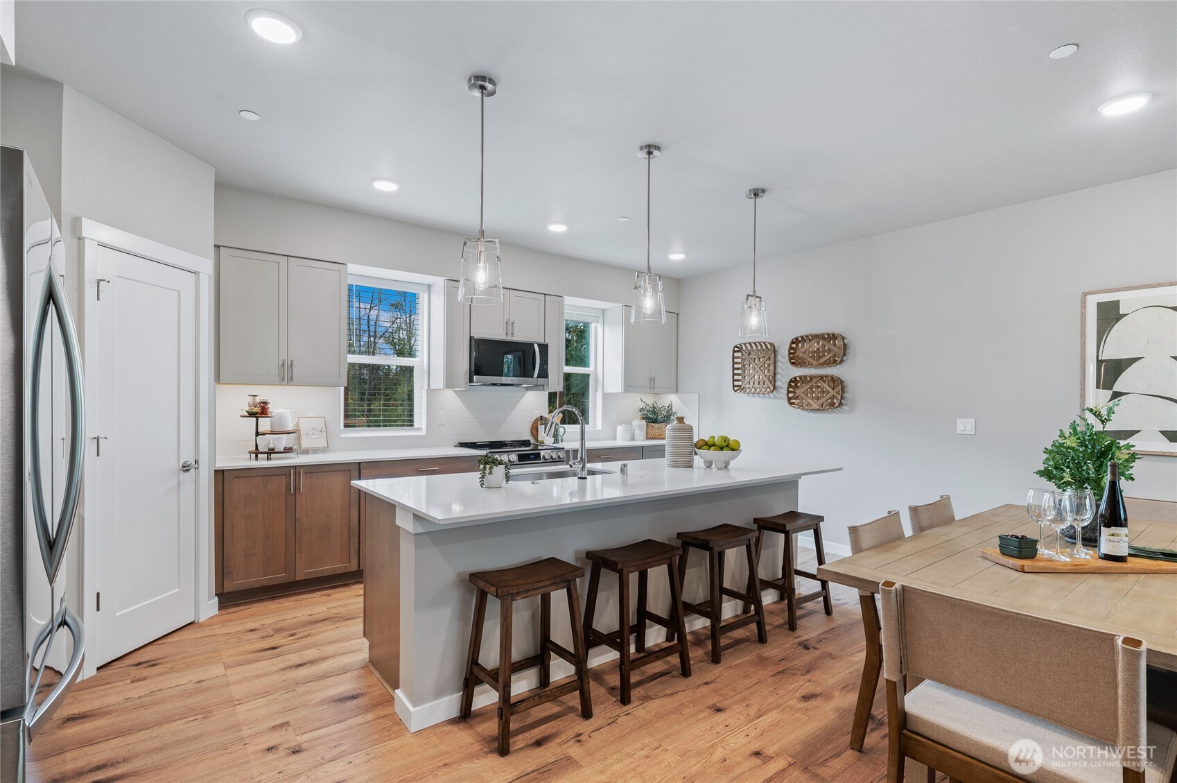 Chef's kitchen with quartz counter tops, full height kitchen backsplash, designer pendant lighting over the entertainers island. Energy efficient LG appliances included.  Photos are of model home in the community.