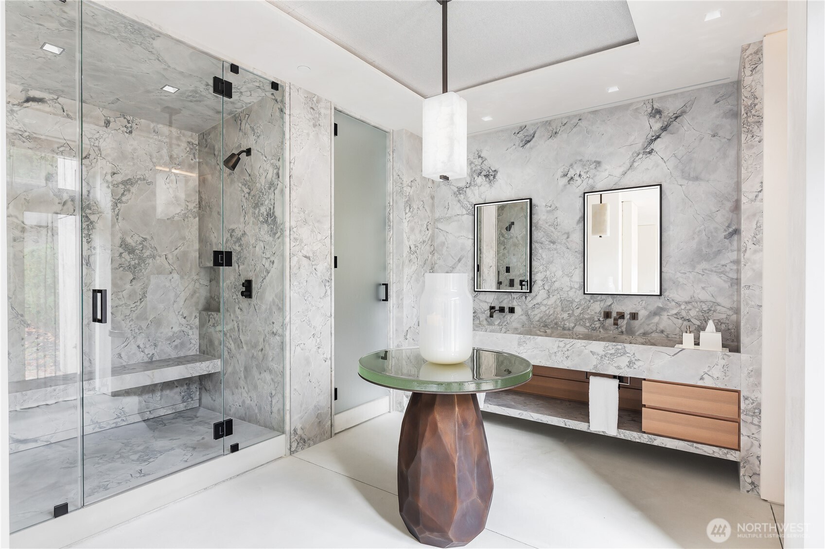 Primary bathroom suite finished in solid Italian Marble, center island table, steam shower.