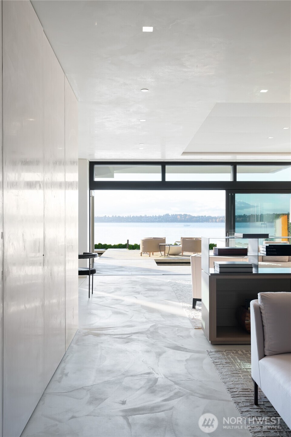 Soft concrete floors and venetian plaster ceilings and walls reflect the light from Lake Washington. Hidden office on the left side behind panel doors, library sitting area to the right.