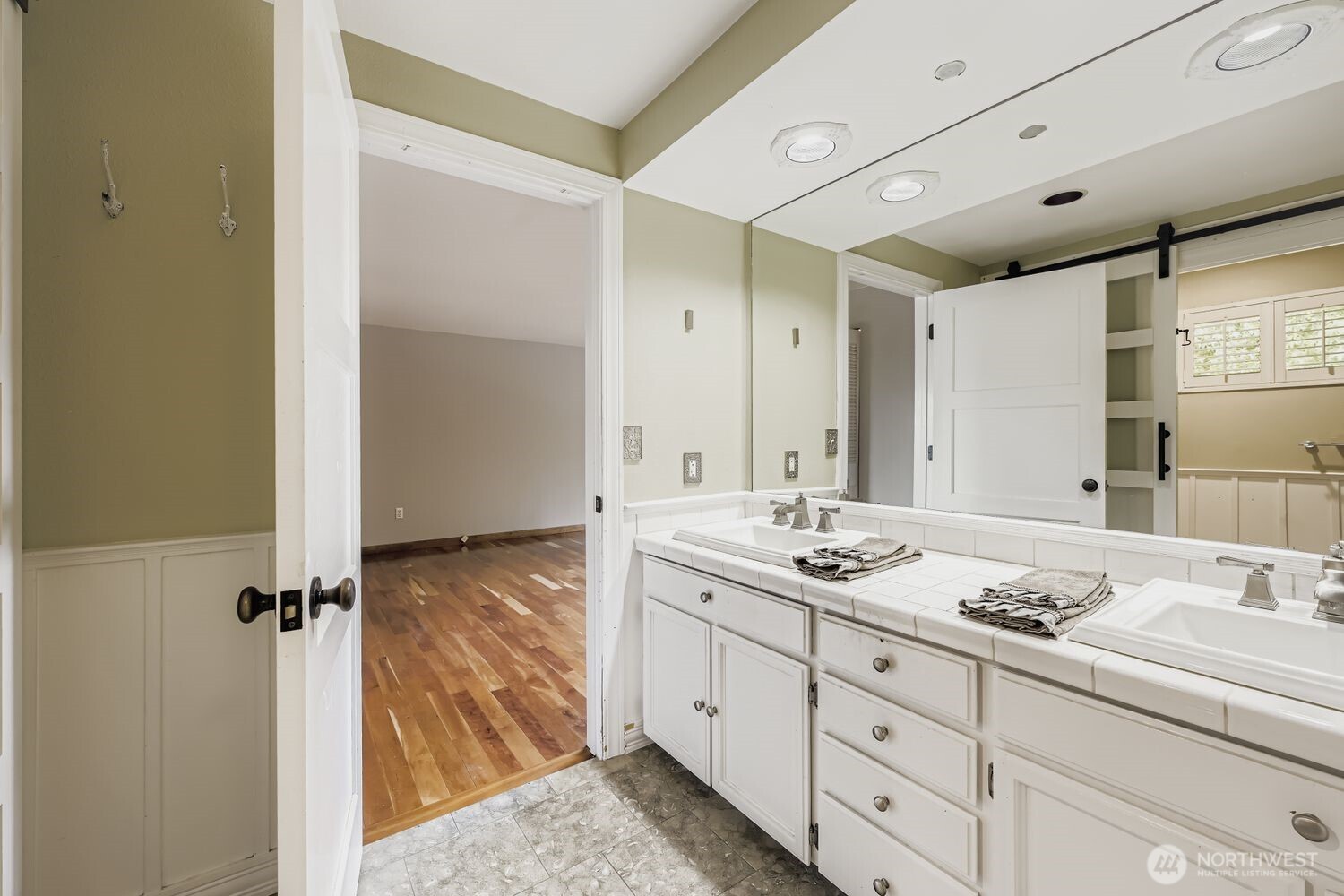 Dual sinks, tile countertops and abundant cabinetry in the Primary bath.  Check out the solid core interior doors which are found throughout this home.