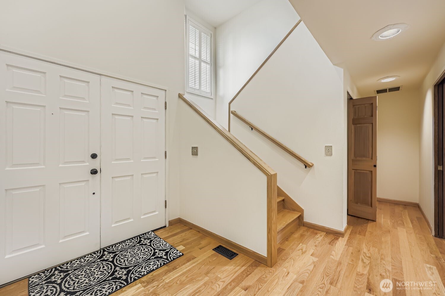An inviting front entry with soaring ceilings, interesting angles, gleaming hardwood floors and abundant light.