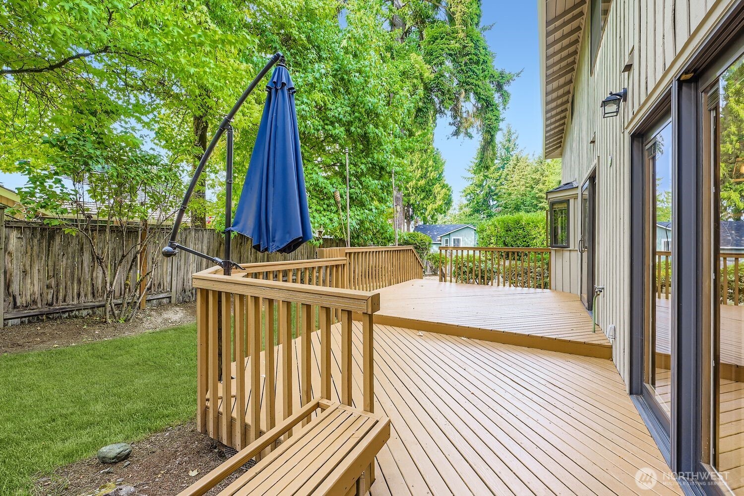 A new fence is now installed.    Another view of the deck and back of the home with a built-in bench.