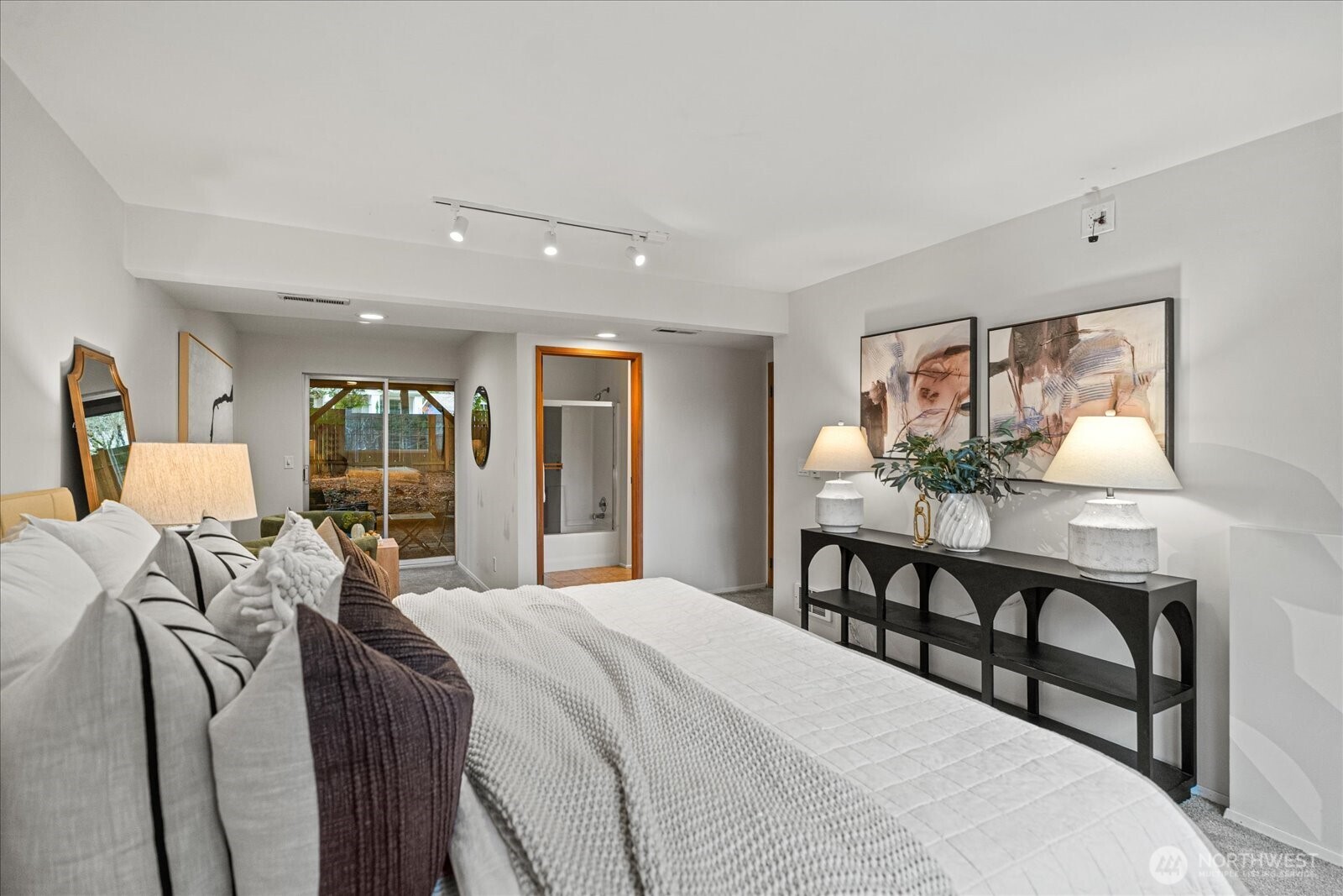 Downstairs features a generous third bedroom retreat with an en suite bath and comfortable sitting area. It opens directly to the outdoor patio and backyard beyond creating a seamless indoor outdoor space, ideal for relaxation.