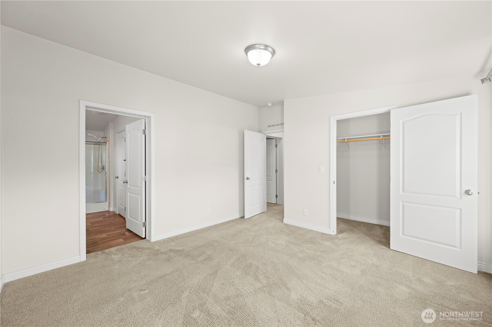 The spacious primary bedroom includes a large closet and an adjoining ensuite bath, designed for everyday comfort.