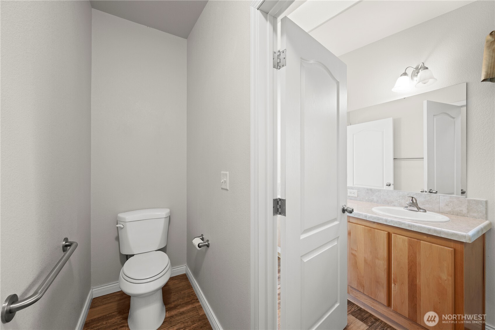 The master bathroom includes a private restroom area, complete with a door and an assist bar on the wall if needed, combining privacy and convenience.