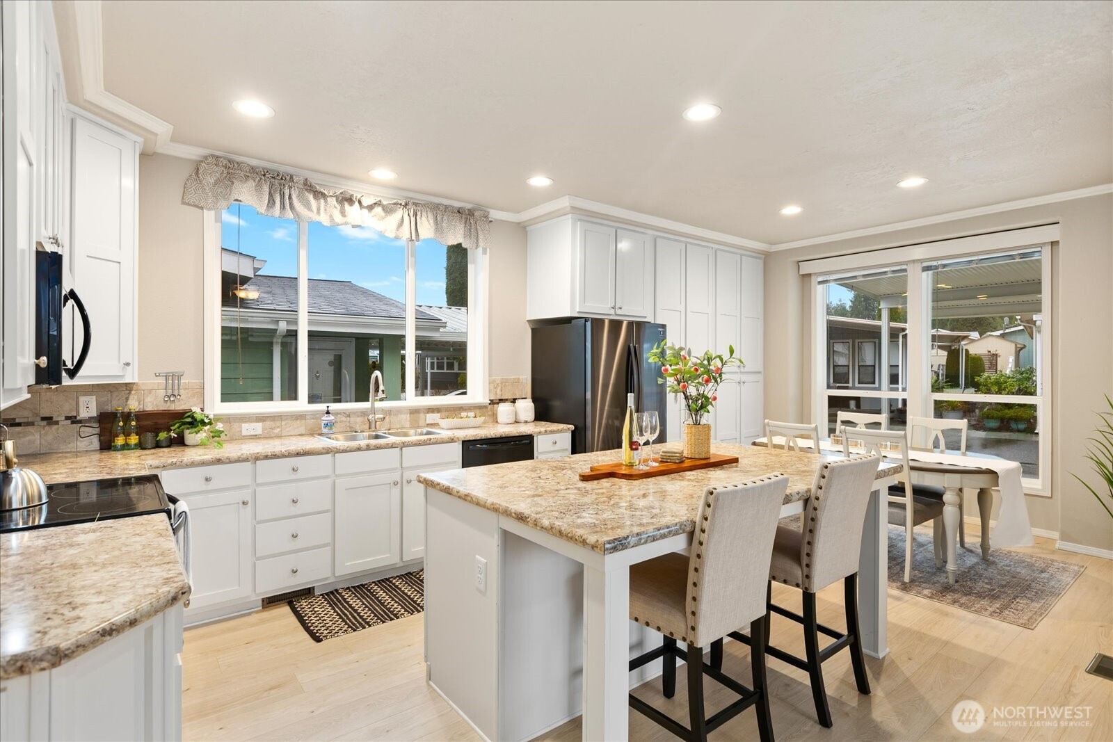 Open bright kitchen with island/bar for eating.