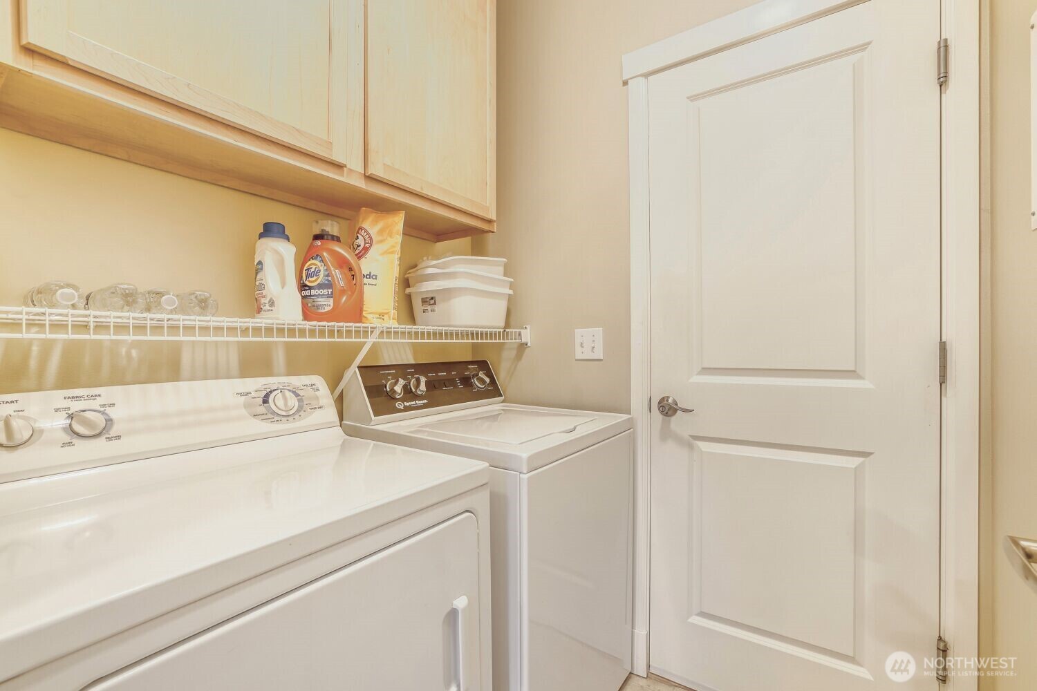 Laundry room with a full size washer and dryer, plus additional cabinet space.