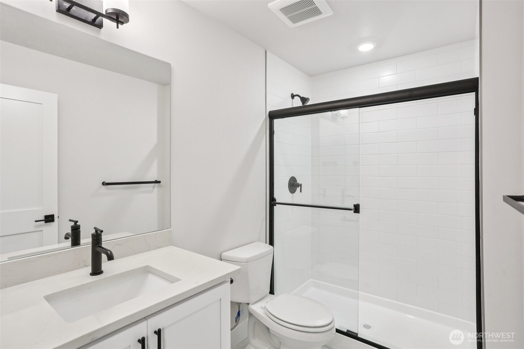 Lower level ensuite bath highlights upgraded matte black finishes found throughout the home.