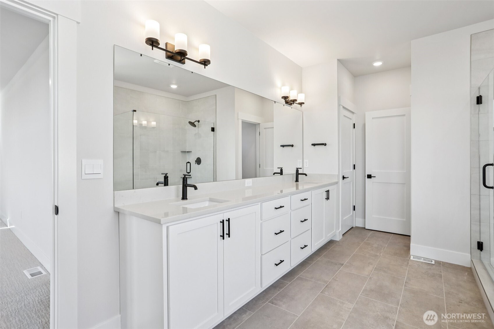 Dual vanity with extensive cabinetry plus linen closet highlights the primary bathroom.