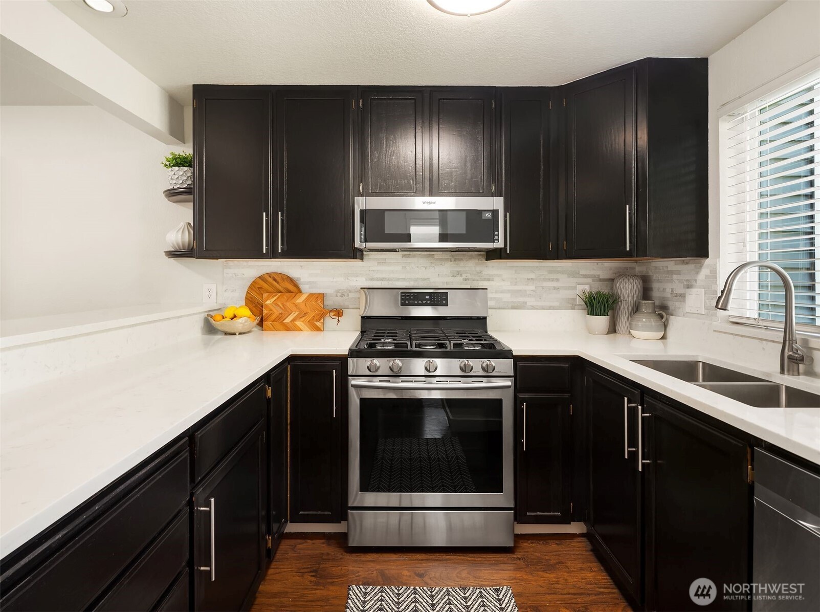 The updated kitchen shines with sleek quartz countertops, gas cooktop, stainless steel appliances, and trendy design that elevates everyday living and entertaining.