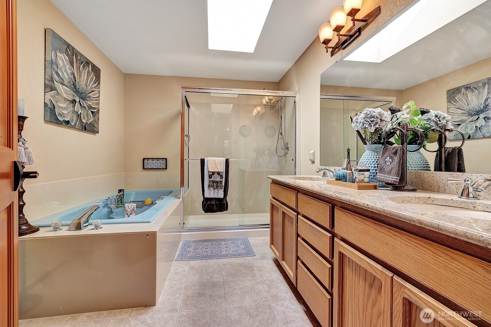 Primary bath with double vanity featuring granite countertops, large soaking tub and walk-in-shower