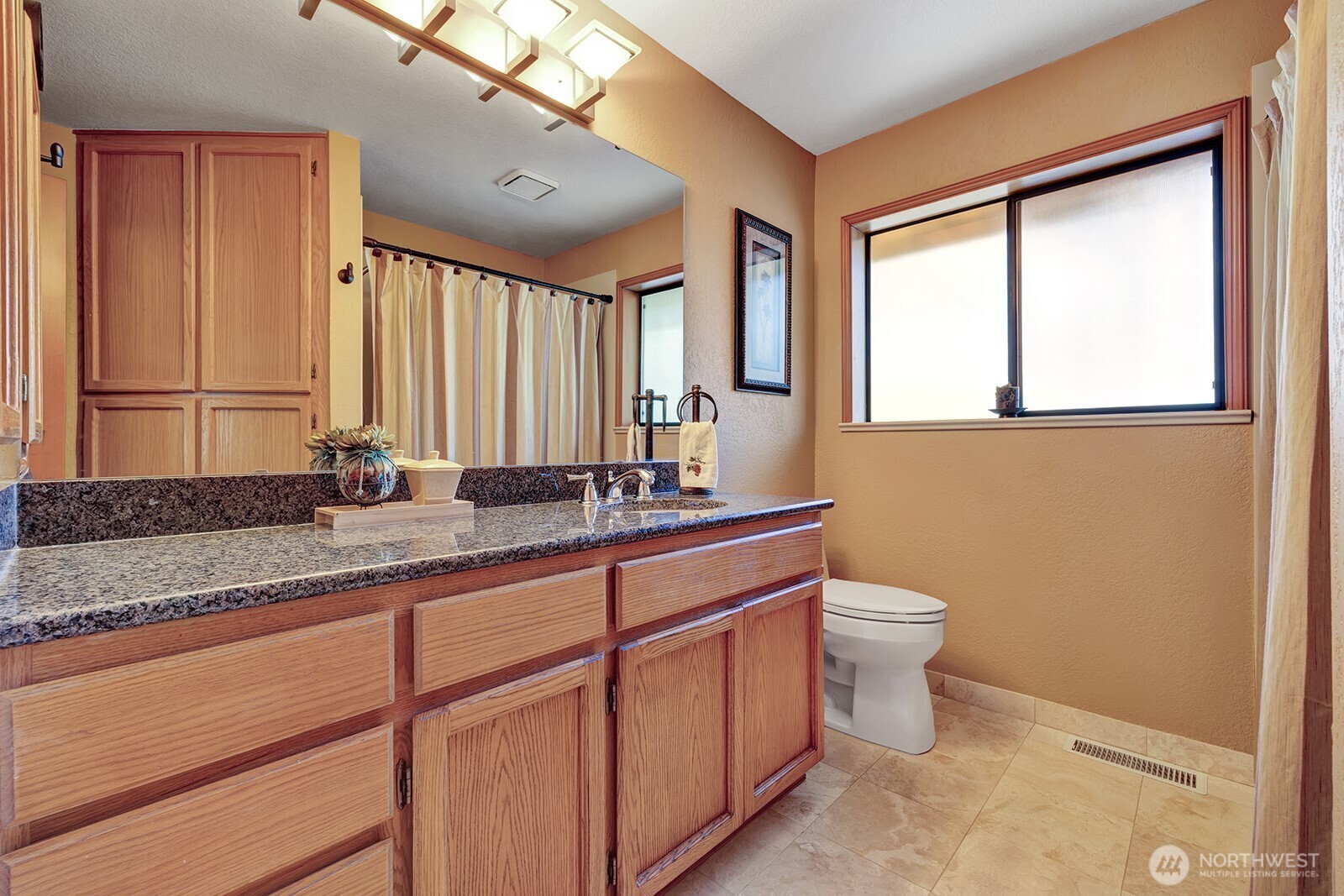 Guest bathroom features granite countertops and updated lighting in all baths