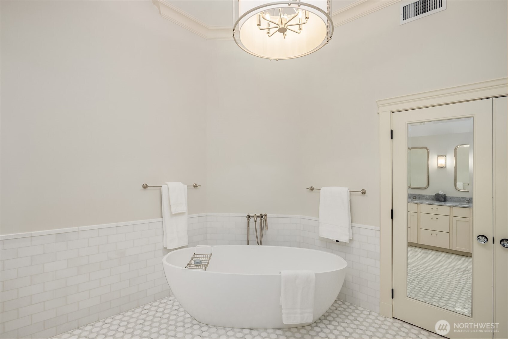 The primary bathroom adorns Ann Sacks tile and designer lighting.