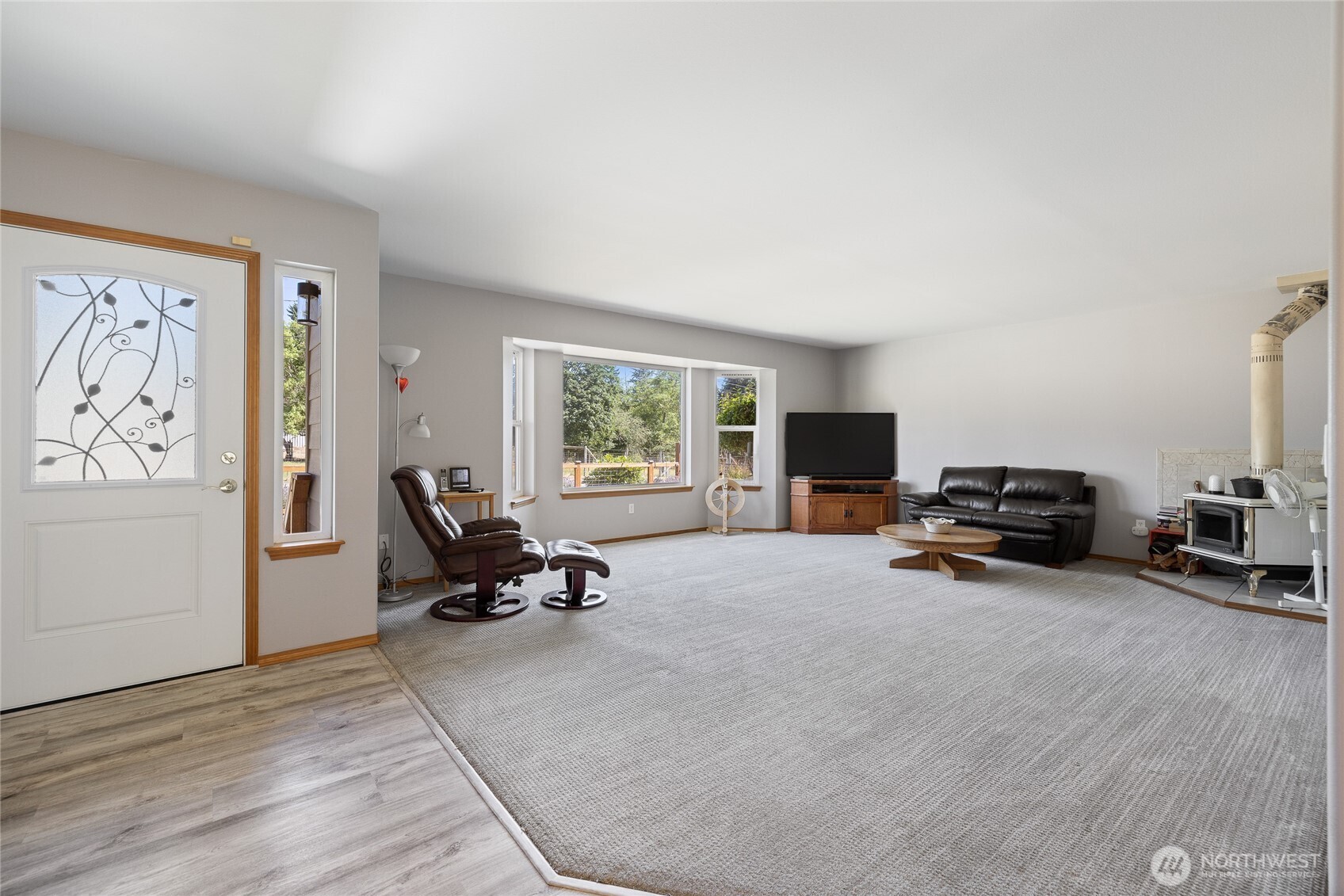 View of living room- Comfort was thoughtfully considered, with additional attic insulation, rigid metal ductwork, and insulated interior walls between living and bedroom spaces for sound dampening. A certified wood stove with a double-insulated pipe provides cozy ambiance and was professionally serviced in March 2025.