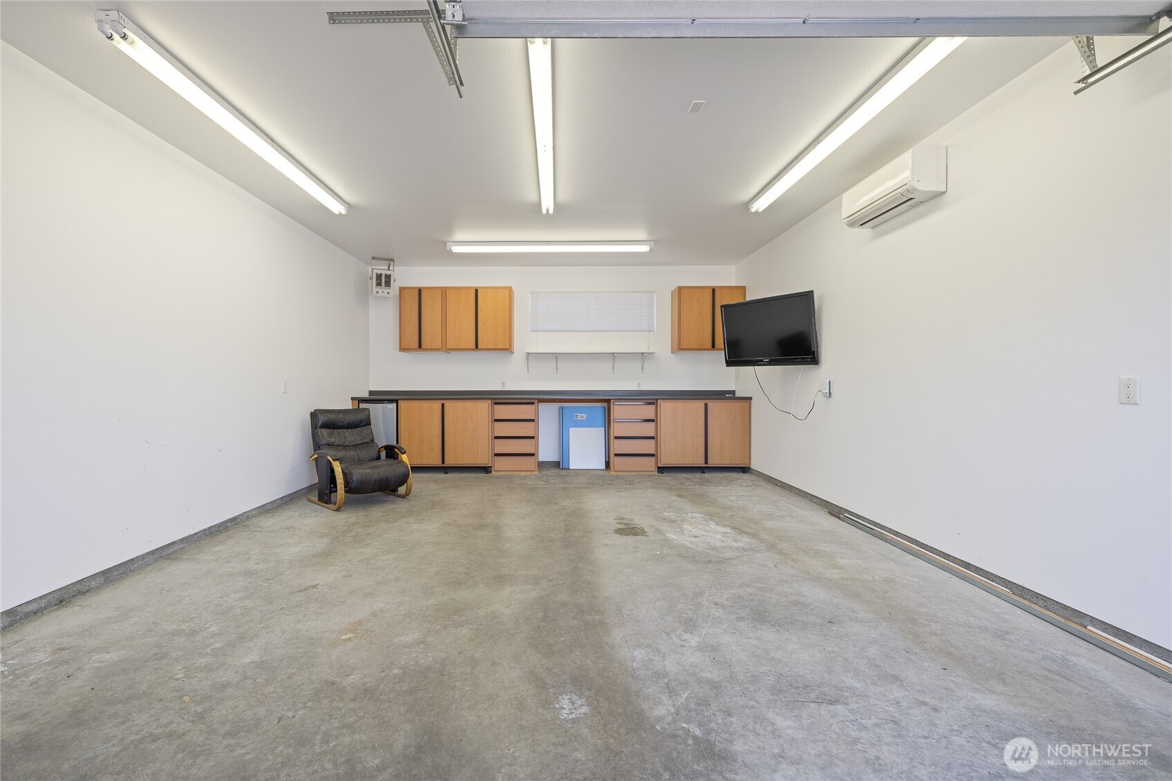 The garage and shop are fully insulated and equipped with a ductless heat pump for year-round usability. The space is piped for an air compressor, which stays with the property, and includes a 50-amp outlet for electric vehicle charging. Built-in cabinetry and a mini fridge are included, along with a dedicated gun safe cabinet (safe not included). A 220-volt welding plug and a 200-amp service panel support a wide range of uses.