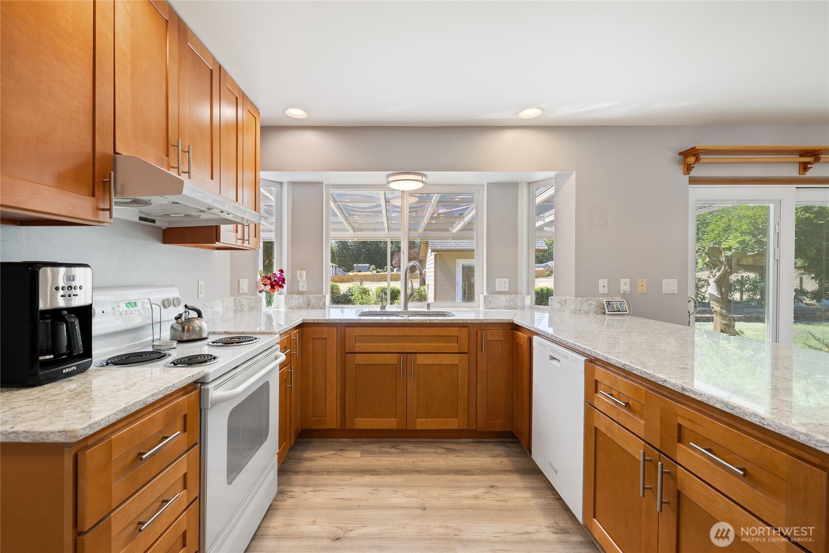 The kitchen was remodeled in 2023 and features quartz countertops, upgraded hardwood cabinetry, and durable LVP flooring. A built-in 48-bottle wine fridge completes the space.