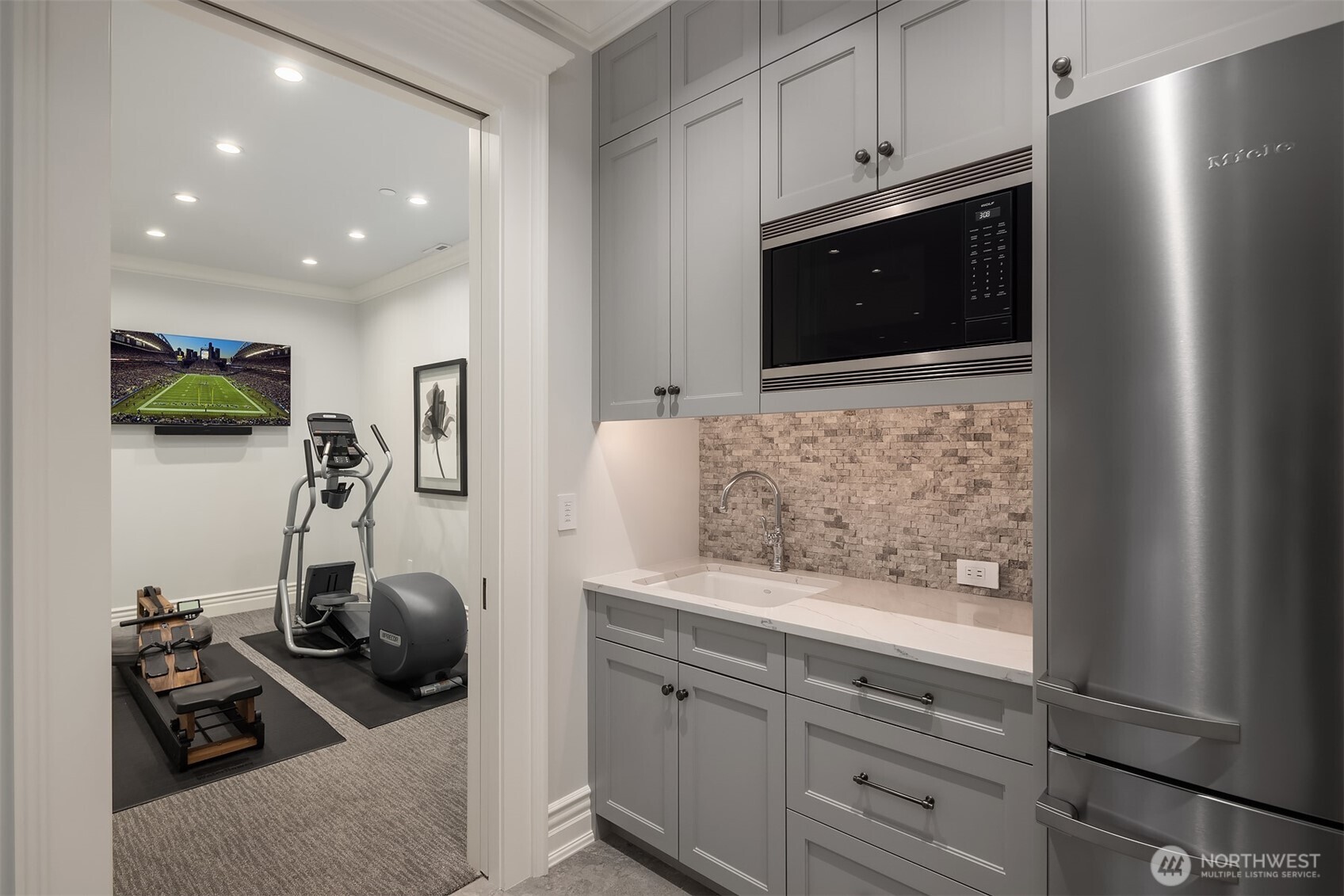 Lower level exercise suite with adjacent bistro kitchen.