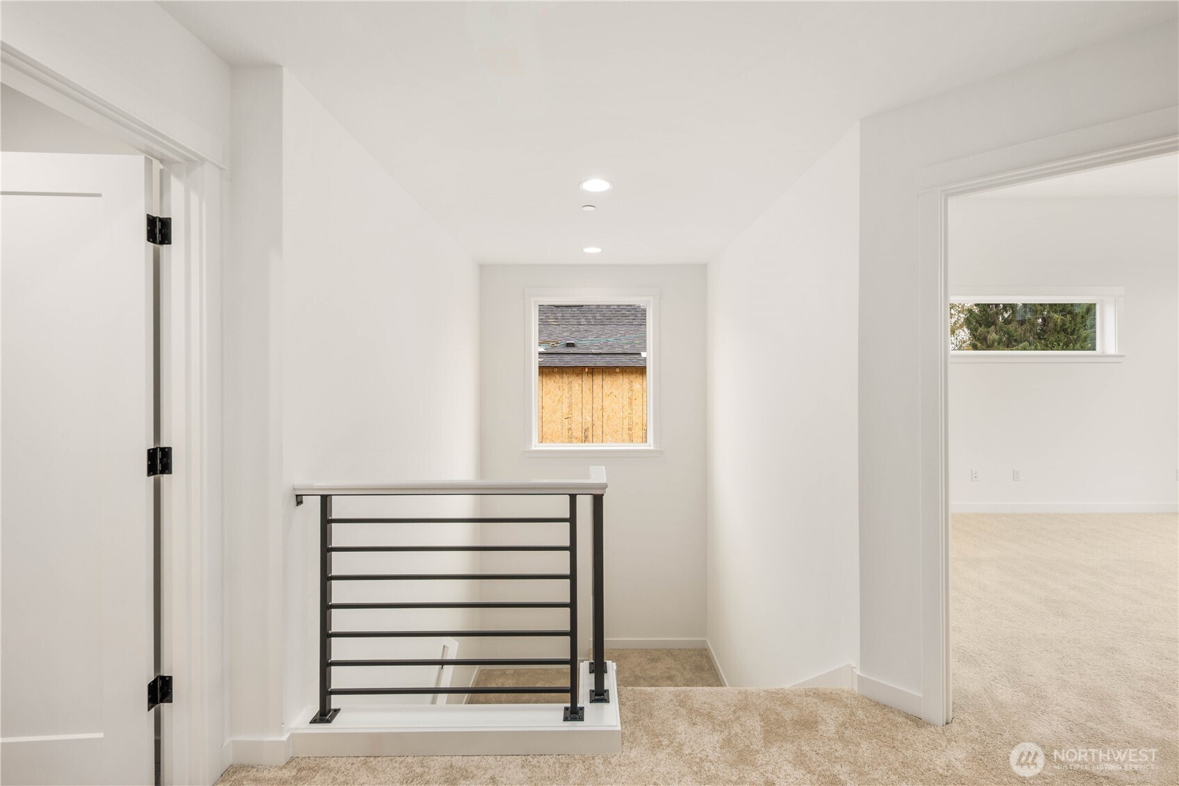 The upper landing provides a bright transition space with a modern metal railing and a window that brings in soft natural light. This open landing creates a comfortable flow between the bedrooms and upstairs spaces.     These photos are from lot 3 at Gooden Hollow, the actual home for sale. However, other homes may vary, so all photos, renderings, site maps, and floorplans are for visualization purposes only. Plans, colors, building orientation, finishes, home outlook, and other details can and WILL vary.