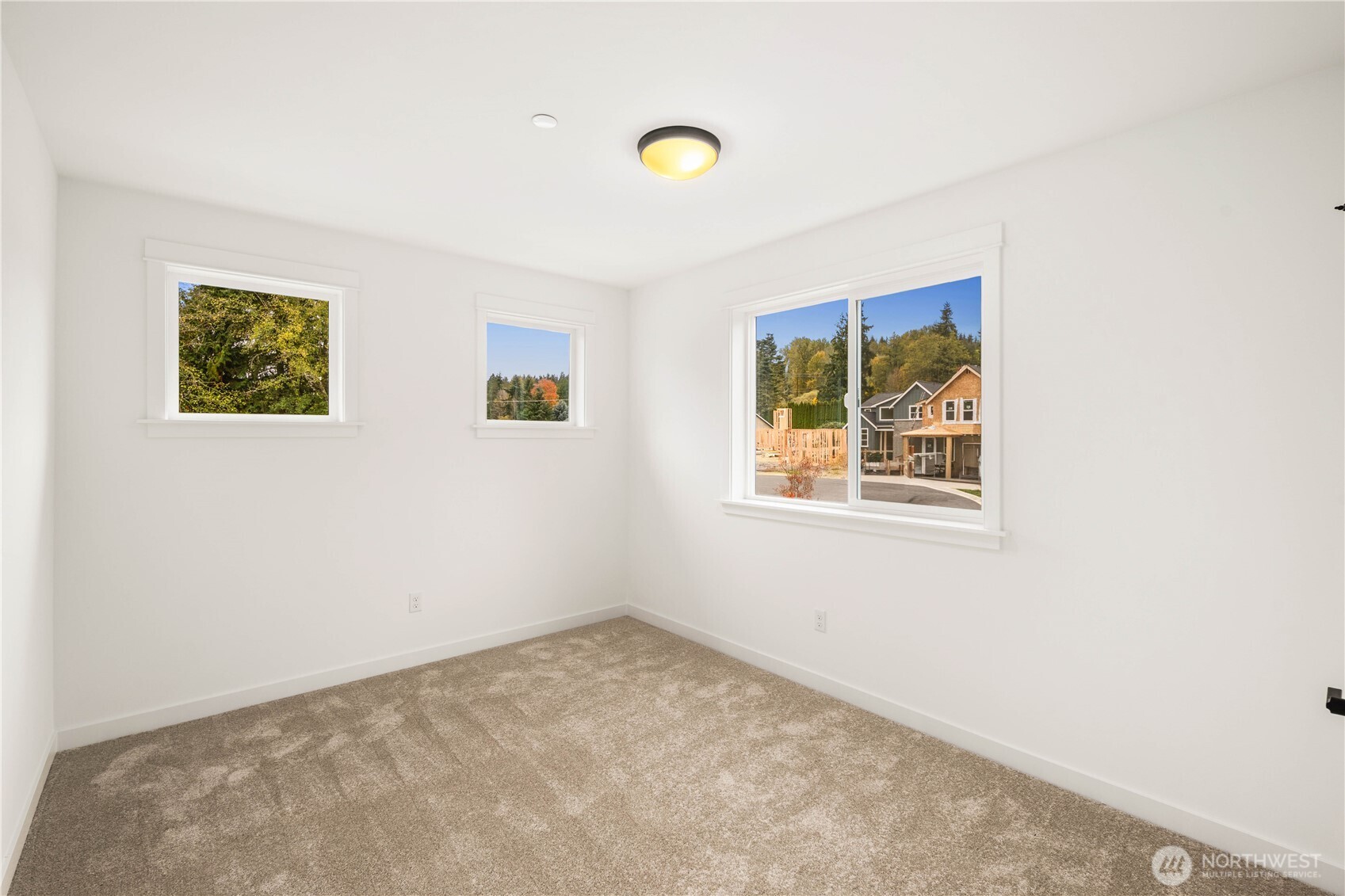 Large windows bring in beautiful natural light and showcase neighborhood and treetop outlooks from this upper-level bedroom. With a spacious footprint and flexible layout, it easily functions as a restful sleeping space or a bright home office.    These photos are from lot 3 at Gooden Hollow, the actual home for sale. However, other homes may vary, so all photos, renderings, site maps, and floorplans are for visualization purposes only. Plans, colors, building orientation, finishes, home outlook, and other details can and WILL vary.