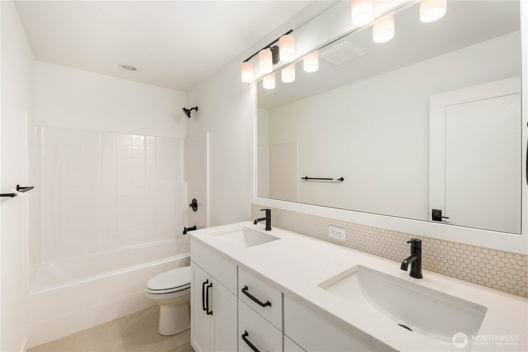 This upper-level bathroom blends clean modern lines with practical everyday function, offering dual sinks, black fixtures, and ample counter space. Its bright layout and timeless finishes make it an easy fit for busy household routines.    These photos are from lot 3 at Gooden Hollow, the actual home for sale. However, other homes may vary, so all photos, renderings, site maps, and floorplans are for visualization purposes only. Plans, colors, building orientation, finishes, home outlook, and other details can and WILL vary.