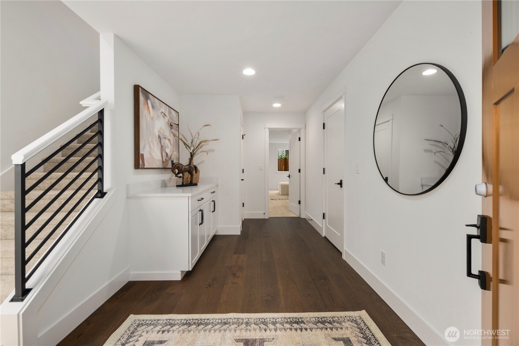 Entry Foyer: Inviting entry foyer with hardwood-style floors, fresh white millwork, and built-in storage cabinetry. The thoughtful design sets the stage for the home’s modern style while connecting seamlessly to the lower-level suite and garage.    Photos are from the model home at Foxmoore and for visualization purposes only. Plans, colors, building orientation, finishes, home outlook, and other details can and WILL vary.
