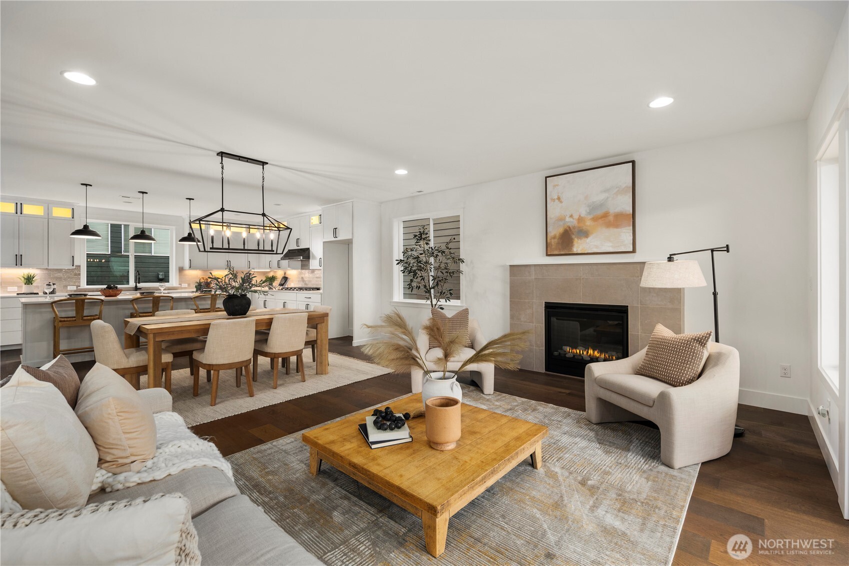 Great Room: Light-filled great room centers on a sleek gas fireplace framed by tile surround and expansive windows. The open layout blends comfort and sophistication, with direct flow to dining and kitchen for effortless entertaining.    Photos are from THIS model home at Foxmoore but are for visualization purposes only.