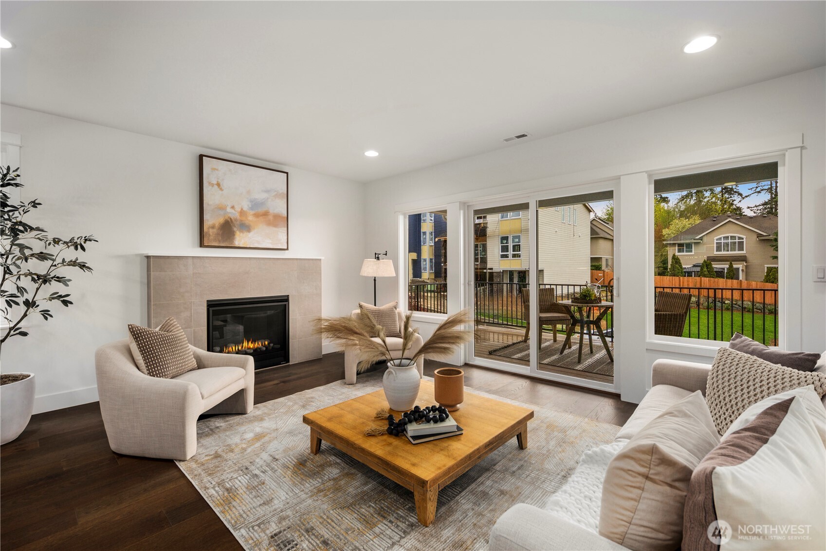 Great Room with Balcony Access: Sliding glass doors open to a covered outdoor patio, extending living space into the fresh Northwest air. Perfect for morning coffee or evening relaxation, this space enhances indoor-outdoor connection with a fully fenced backyard beyond.    Photos are from THIS model home at Foxmoore but are for visualization purposes only.  Photos are from the model home at Foxmoore and for visualization purposes only. Plans, colors, building orientation, finishes, home outlook, and other details can and WILL vary.